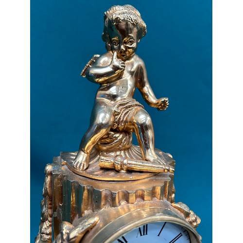 365 - A heavy gilt metal mantel clock surmounted by a winged cherub. Battery movement