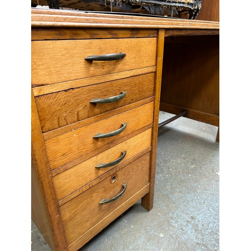 411 - A mid century honey coloured oak desk with metal foot rail stretcher - formica added to top but soli... 