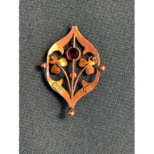 34 - An Edwardian Art Nouveau style 9ct gold pendant designed as shamrocks and a flower, set with a red s... 