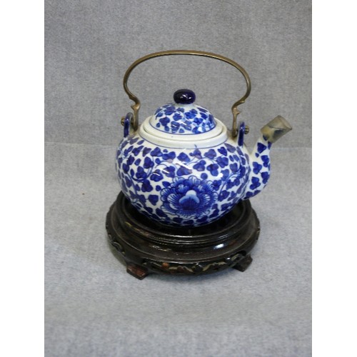 72 - AN ORIENTAL EARTHENWARE TEAPOT AND STAND, HANDCRAFTED IN THAILAND, WITH BRASS HANDLE