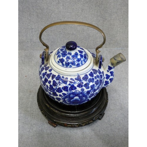 72 - AN ORIENTAL EARTHENWARE TEAPOT AND STAND, HANDCRAFTED IN THAILAND, WITH BRASS HANDLE