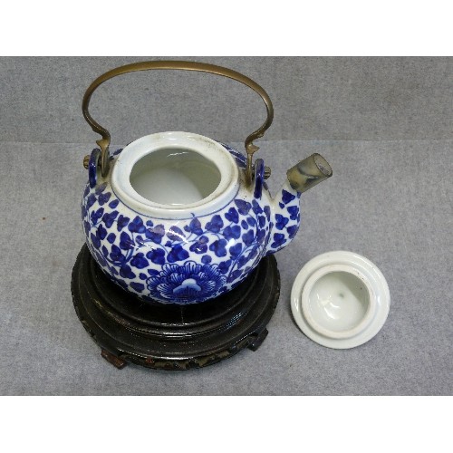 72 - AN ORIENTAL EARTHENWARE TEAPOT AND STAND, HANDCRAFTED IN THAILAND, WITH BRASS HANDLE