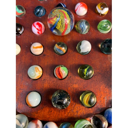 305 - An Antique mahogany solitaire board with a good collection of antique and vintage glass marbles