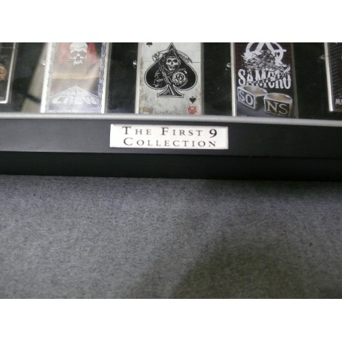 44 - A COLLECTION OF 9 SONS OF ANARCHY IN DISPLAY CASE  ZIPPO STYLE LIGHTERS