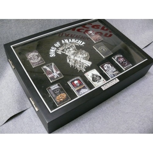 44 - A COLLECTION OF 9 SONS OF ANARCHY IN DISPLAY CASE  ZIPPO STYLE LIGHTERS