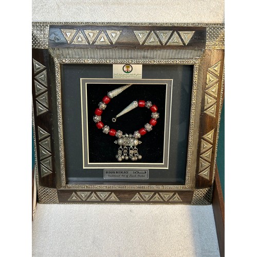 109 - A presentation Beduin Necklace in a traditional wooden frame decorated with silver panels. In a pres... 