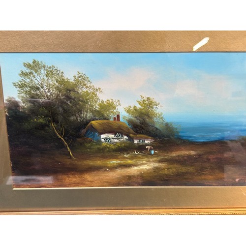 152 - A late Victorian oil painting on board of a thatched cottage on a cliff top with the sea in the dist... 