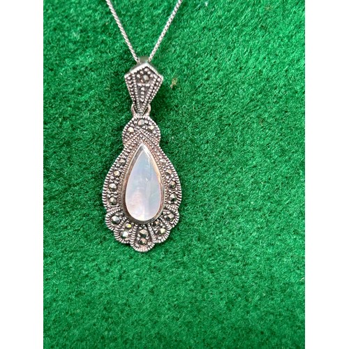 107 - An Art Deco style sterling silver and marcasite pendant set with mother of pearl, on a sterling silv... 