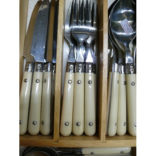 107 - SMART CUTLERY SET WITH RIVETED CREAM HANDLES. CONTAINED IN WOODEN TRAY.