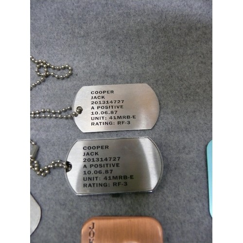 34 - Collection of 8 dog tags, possibly from games.  One is a memory stick, one other looks like a key (p... 