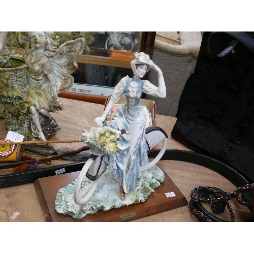 275A - A CERAMIC LADY FIGURINE ON BICYCLE