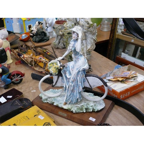 275A - A CERAMIC LADY FIGURINE ON BICYCLE