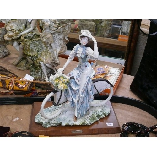 275A - A CERAMIC LADY FIGURINE ON BICYCLE