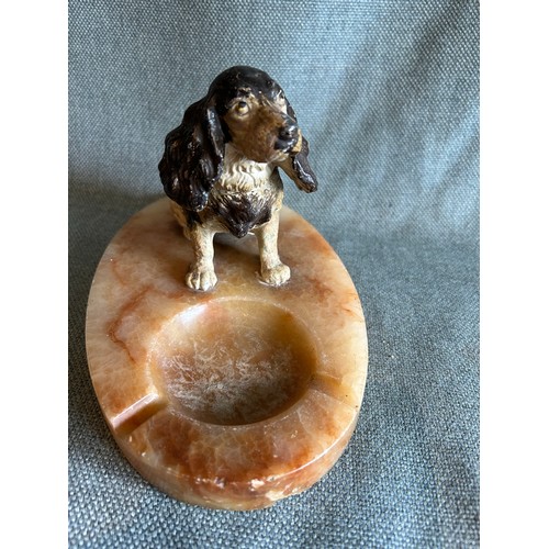 69A - A 1930's onyx ashtray with a cold painted spelter figure of a seated spaniel. 22cm x 14cm