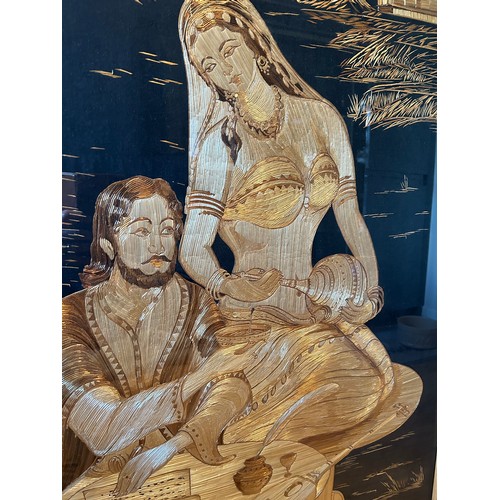 144C - A large 20th Century straw work picture of a religious man and female disciple serving from a ewer -... 