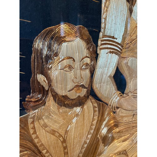 144C - A large 20th Century straw work picture of a religious man and female disciple serving from a ewer -... 