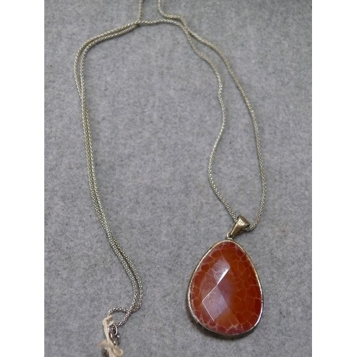 45 - A LARGE HEAVY SILVER PENDANT WITH A LOVELY ORANGE CARNELIAN CRYSTAL STONE ON A 27 INCH SILVER CHAIN