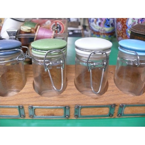 302 - A VINTAGE SPICE SET WITH JARS WITH COLOURED LIDS IN A WOODEN RACK