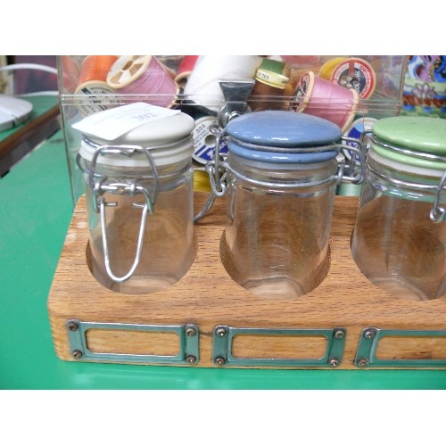 302 - A VINTAGE SPICE SET WITH JARS WITH COLOURED LIDS IN A WOODEN RACK