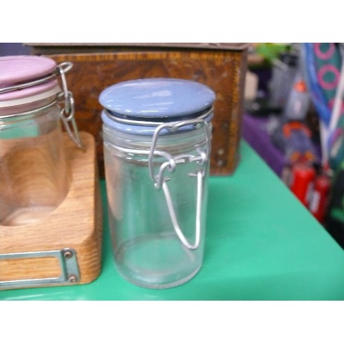 302 - A VINTAGE SPICE SET WITH JARS WITH COLOURED LIDS IN A WOODEN RACK