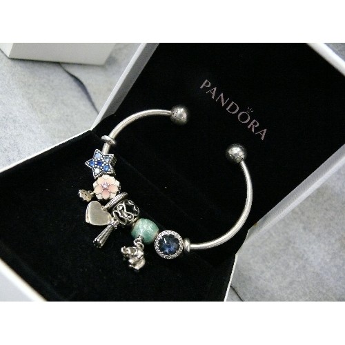 17 - A PANDORA SILVER CHARM BANGLE, LOTS OF CHARMS, BOXED