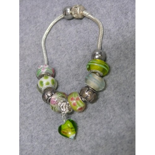 66 - A LOVELY PINK AND GREEN CHARM BRACELET WITH GLASS BEADS MARKED 925