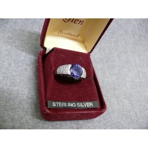 34 - A SOLID SILVER RING WITH A LARGE LIGHT PURPLE STONE SIZE Q