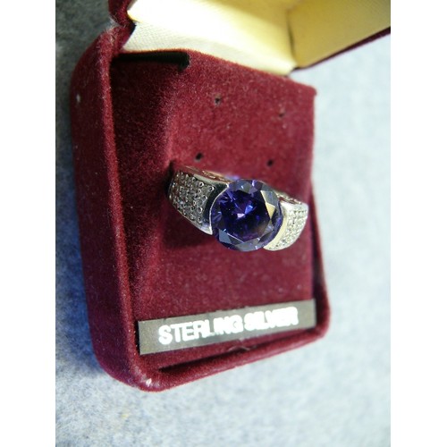 34 - A SOLID SILVER RING WITH A LARGE LIGHT PURPLE STONE SIZE Q