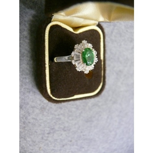 43 - A FINE SOLID SILVER DRESS RING A BEAUTIFUL OVEL EMERALD COLOURED STONE SURROUNDED BY BAGUETTE WHITE ... 