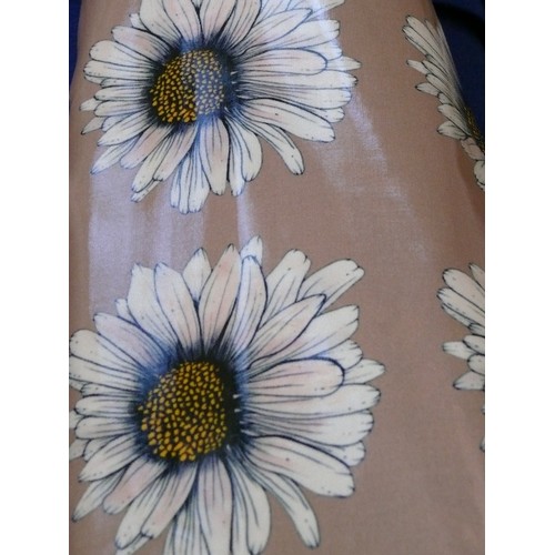 228 - A PART ROLL OF MUSHROOM COLOURED VINYL FABRIC WITH DAISY DESIGN