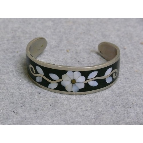 13 - A SOLID SILVER BANGLE WITH BLACK ENAMEL WITH MOTHER OF PEARL SET IN