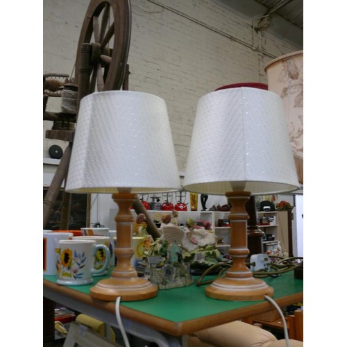 373 - A PAIR OF WOODEN BEDSIDE LAMPS PLUS 2 ORNATE WOODEN BASED TABLE LAMPS ALL WITH SHADES