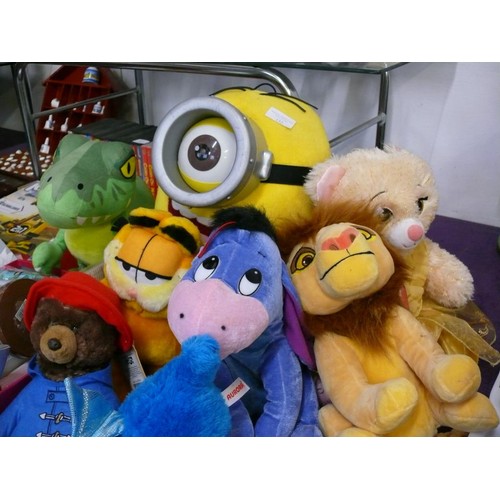 132 - A COLLECTION OF SOFT TOYS TO INCLUDE A MINION, GARFIELD, PADDINGTON, THE LION KING, EEYORE AND FRIEN... 