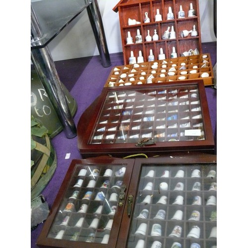 142 - A LARGE COLLECTION OF CERAMIC THIMBLES AND BELLS IN WOODEN DISPLAY CASES