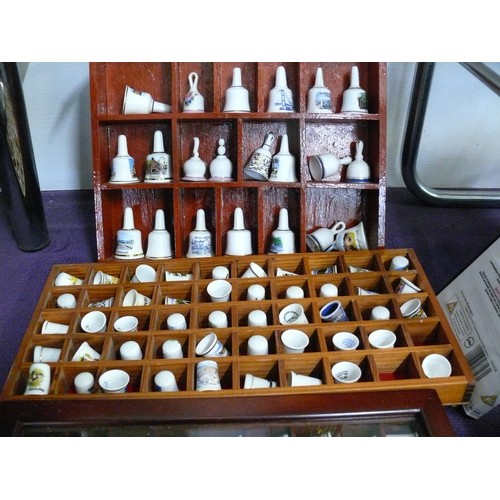 142 - A LARGE COLLECTION OF CERAMIC THIMBLES AND BELLS IN WOODEN DISPLAY CASES