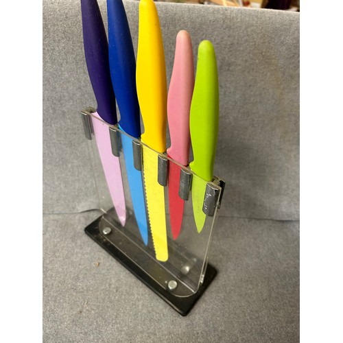 465 - A SET OF COLOURFUL KITCHEN KNIVES IN A CLEAR STAND