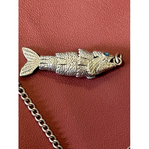 34 - A SILVER INGOT ON SILVER CHAIN AND ARTICULATED FISH PENDANT WITH BLUE EYES