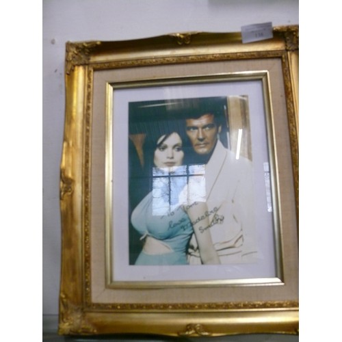 138 - FRAMED AND GLAZED JAMES BOND ROGER MOORE AND MADELINE SMITH PHOTOGRAPH SIGNED BY MADELINE SMITH