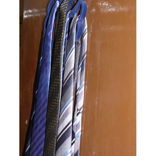 232 - A GOOD SELECTION OF MENS NECK TIES ON A WARDROBE HANGER.