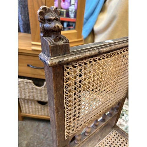 294F - ANTIQUE OAK SIDE CHAIR WITH UNUSUAL CARVED LION HEAD SIDE RAIL FINIALS - CANEWORK SEAT AND BACK