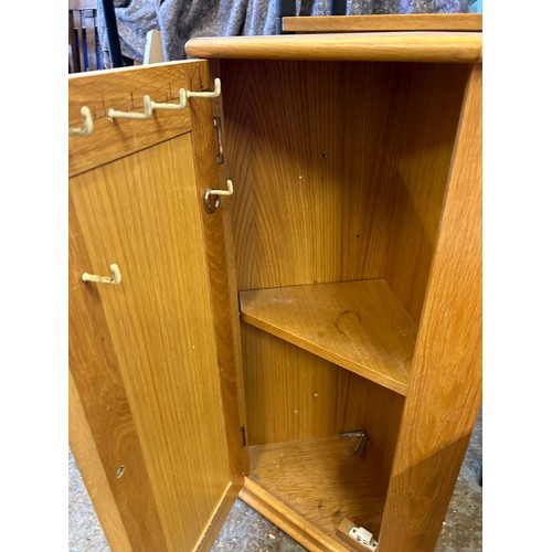 294K - Small corner cupboard in pale oak with bevelled mirror panel