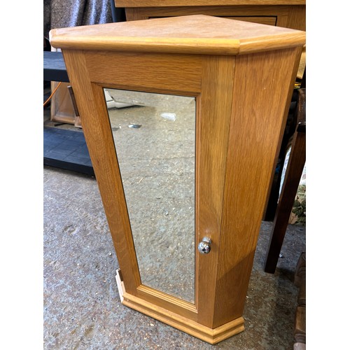 294K - Small corner cupboard in pale oak with bevelled mirror panel