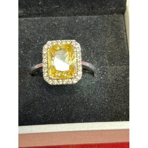 25 - A SOLID SILVER RING WITH A SPARKLY  YELLOW CRYSTAL SIZE O.HALF