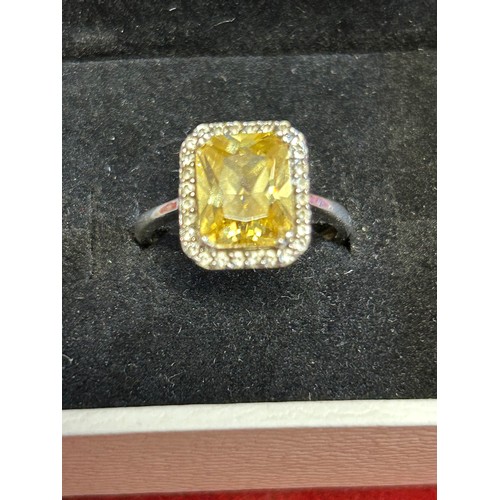 25 - A SOLID SILVER RING WITH A SPARKLY  YELLOW CRYSTAL SIZE O.HALF