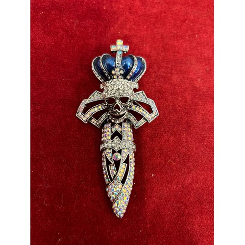 39 - A LARGE BUTLER & WILSON HIGHLY DECORATED SKULL ON A CROSS UNDER CROWN ENCRUSTED WITH GEM STONES COST... 