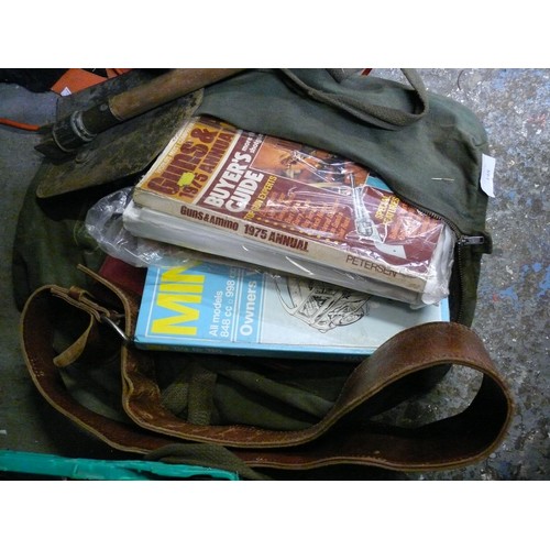 148 - GREEN BAG WITH CONTENTS OF GUN BOOKS, MINI CAR BOOKS, TRENCHING TOOL AND WEIGHT LIFTING BELT