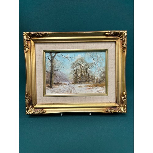 150 - J Caesar-Smith. A small original oil painting on board of a winter landscape with distant figure gat... 