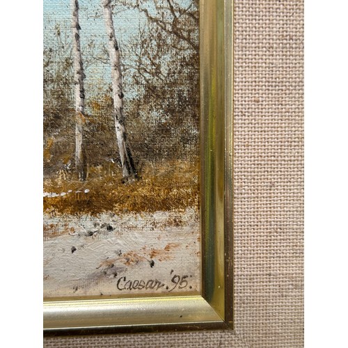 150 - J Caesar-Smith. A small original oil painting on board of a winter landscape with distant figure gat... 