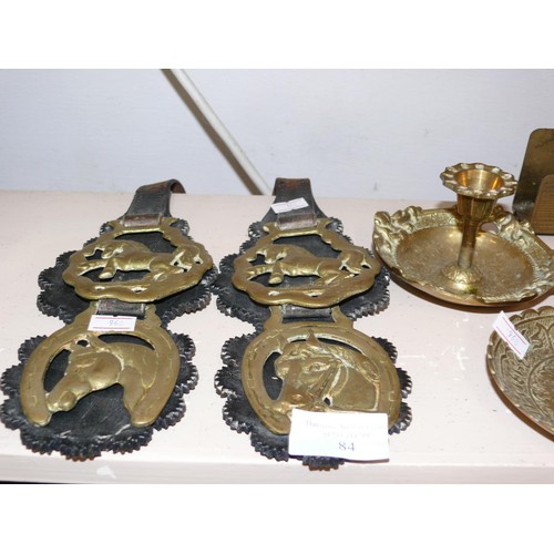 84 - COLLECTION OF BRASS ITEMS TO INCLUDE  HORSE BRASSES ON LEATHERS, CANDLESTICKS, SHELL CASES ETC