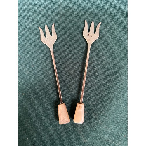 24 - A pair of sterling silver pickle or olive forks, Sheffield 1938 by Viners Ltd, with mother of pearl ... 